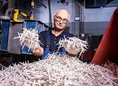 bjb-nachhaltigkeit-mann-mit-recyceltem-kunststoff-in-den-haenden-kunststoffrecycling